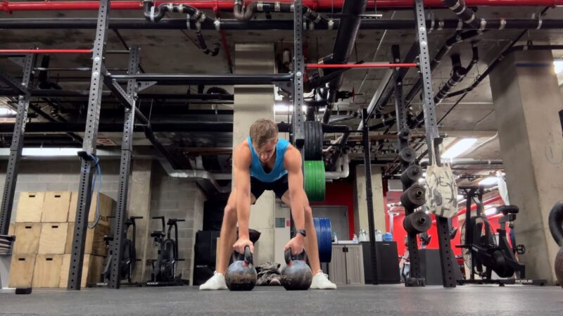 Muškarac u barefoot patikama radi deadlift sa girjama u teretani